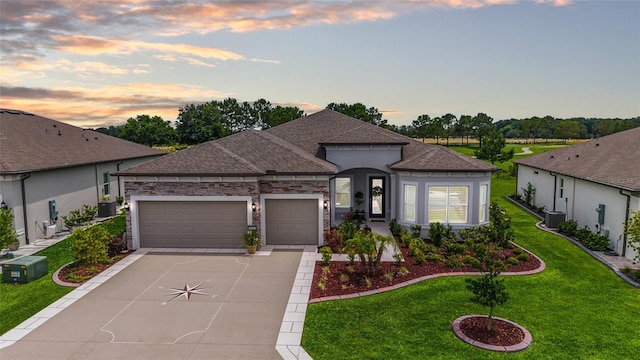 8606 SW 61st Loop, Ocala, FL 34481 - view of front facade featuring driveway, an attached garage, roof with shingles, a yard, and central AC unit
