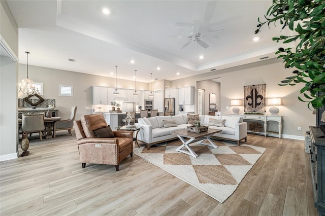 8606 SW 61st Loop, Ocala, FL 34481 - living room with a raised ceiling, ceiling fan, light wood-style flooring, a chandelier, and recessed lighting