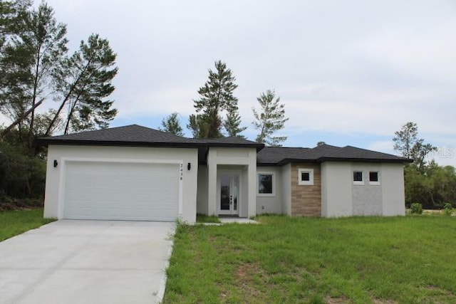 prairie-style home with a garage, driveway, stucco siding, and a front lawn