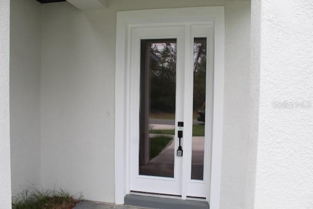 property entrance featuring stucco siding