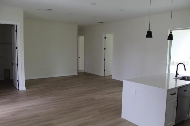 kitchen with a sink, open floor plan, and light wood-style flooring