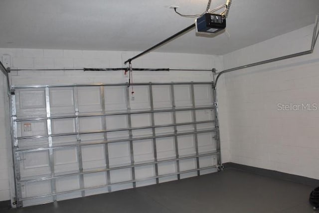 garage featuring a garage door opener and baseboards