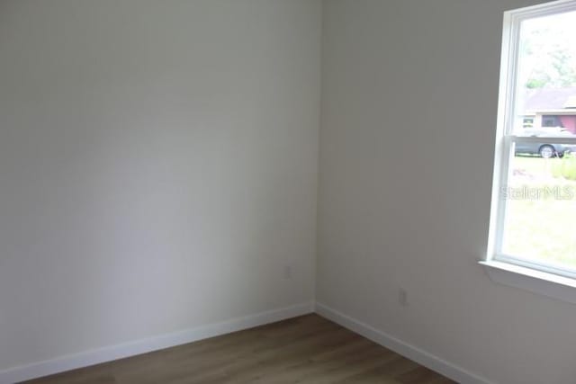 empty room with baseboards and wood finished floors