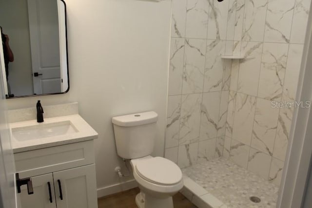 full bath with vanity, a shower stall, toilet, and baseboards