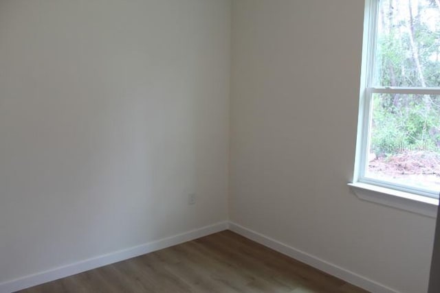 unfurnished room with baseboards and wood finished floors