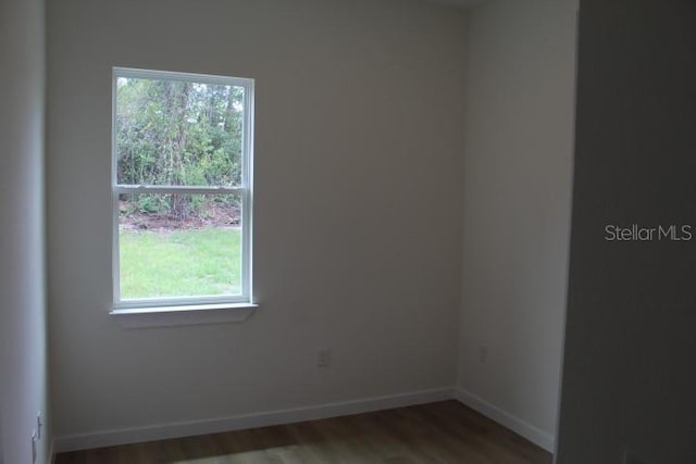 empty room with wood finished floors and baseboards