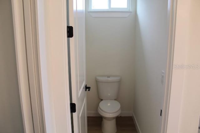 bathroom with toilet and baseboards
