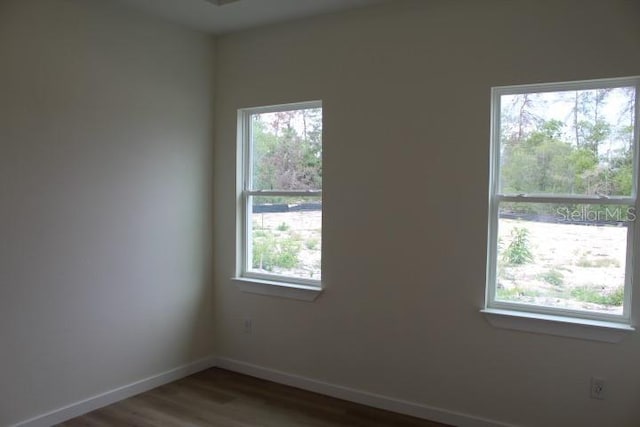 spare room featuring wood finished floors and baseboards