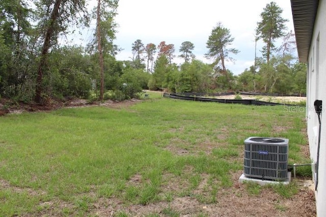 view of green lawn featuring cooling unit