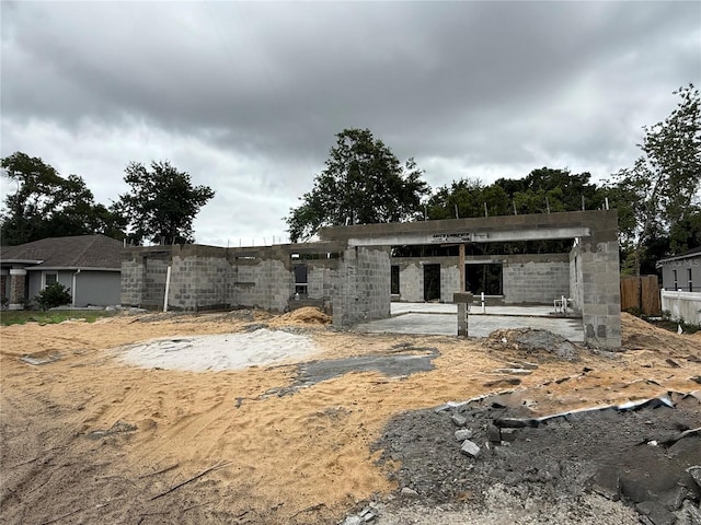 view of front of home with fence, a patio area, and stone siding