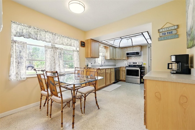 3020 E Scofield St, Inverness, FL 34453 - kitchen with stainless steel appliances, a sink, decorative backsplash, light countertops, and baseboards