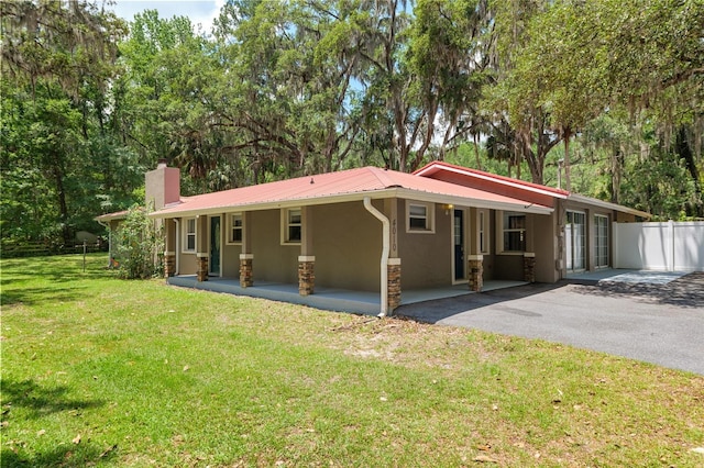 4010 SW 7th Avenue Rd, Ocala, FL 34471 - view of front of home with stucco siding, a chimney, metal roof, stone siding, and driveway