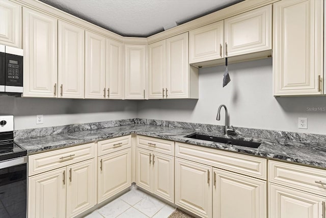 7059 N Lecanto Hwy, Hernando, FL 34442 - kitchen with cream cabinets, stainless steel range with electric stovetop, white microwave, light marble finish floors, and a textured ceiling