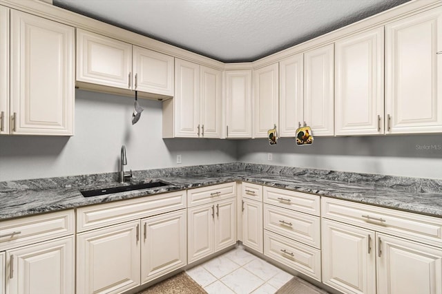 7059 N Lecanto Hwy, Hernando, FL 34442 - kitchen with a sink, a textured ceiling, dark stone counters, and cream cabinets