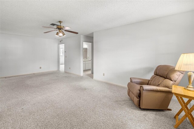 9667 SW 94th Ct Unit C, Ocala, FL 34481 - sitting room featuring a ceiling fan, light carpet, a textured ceiling, and baseboards