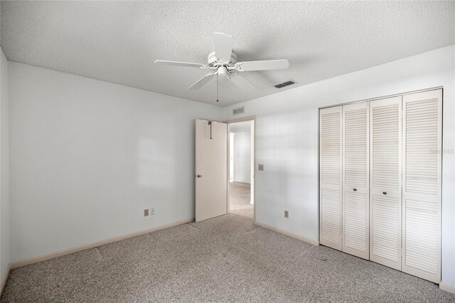 9667 SW 94th Ct Unit C, Ocala, FL 34481 - unfurnished bedroom featuring carpet, a closet, a textured ceiling, ceiling fan, and baseboards