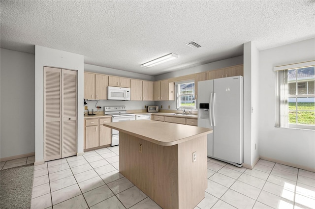 9667 SW 94th Ct Unit C, Ocala, FL 34481 - kitchen with white appliances, light brown cabinetry, a sink, light countertops, and a center island