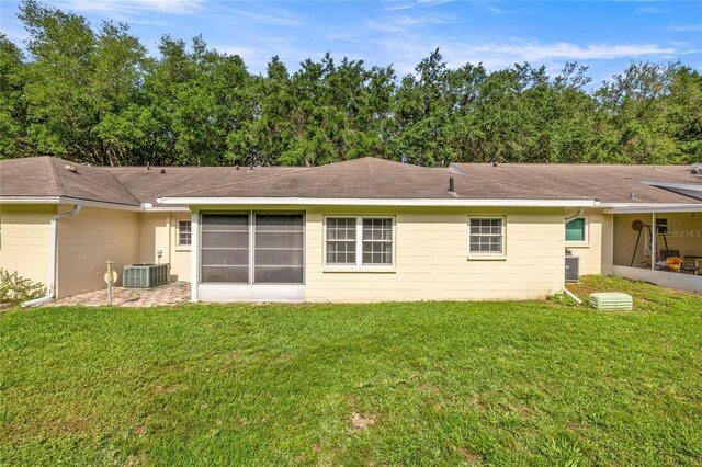 9667 SW 94th Ct Unit C, Ocala, FL 34481 - rear view of house featuring a lawn, central AC unit, and a shingled roof