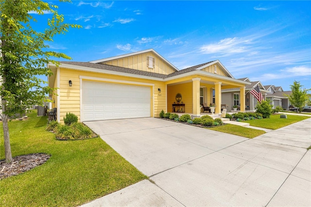 7641 SW 63rd Lane Rd, Ocala, FL 34474 - view of front facade featuring covered porch, board and batten siding, a front yard, and driveway