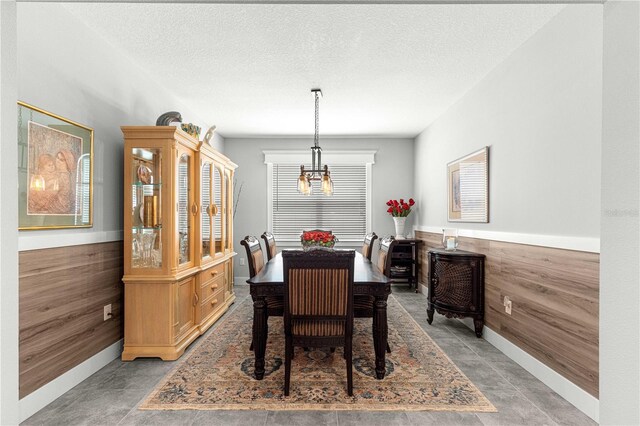 7641 SW 63rd Lane Rd, Ocala, FL 34474 - dining space with a chandelier, a textured ceiling, baseboards, and wood walls