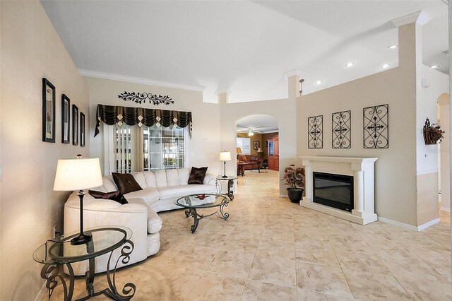 living room featuring a glass covered fireplace, arched walkways, ornamental molding, recessed lighting, and a ceiling fan