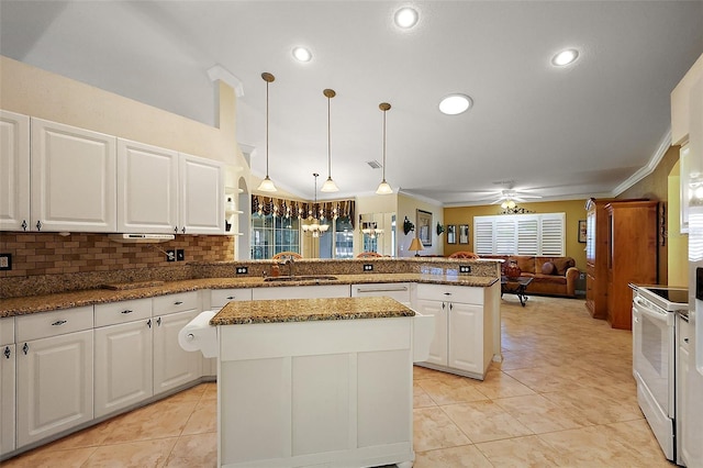kitchen with a peninsula, a sink, white range with electric stovetop, white cabinets, and a kitchen island