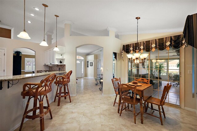 dining area featuring arched walkways, a chandelier, recessed lighting, and baseboards