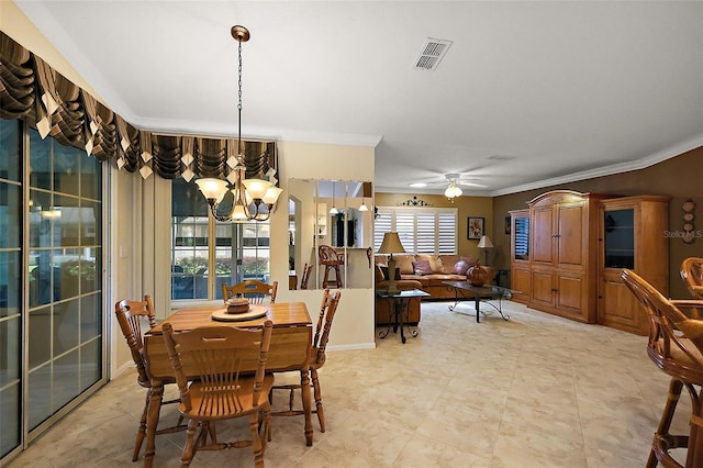 dining space with a chandelier, crown molding, and a ceiling fan