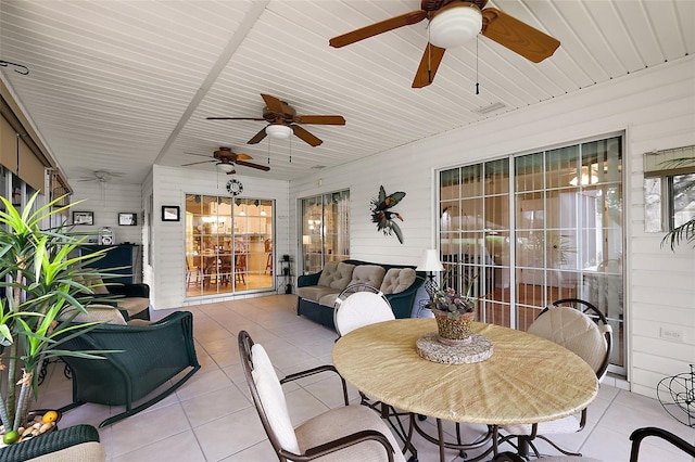 sunroom with a ceiling fan and outdoor dining area