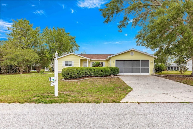 single story home with an attached garage, a front yard, and concrete driveway