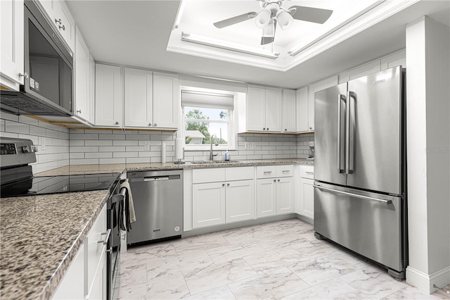 kitchen featuring stainless steel appliances, a sink, light marble finish flooring, a ceiling fan, and white cabinets