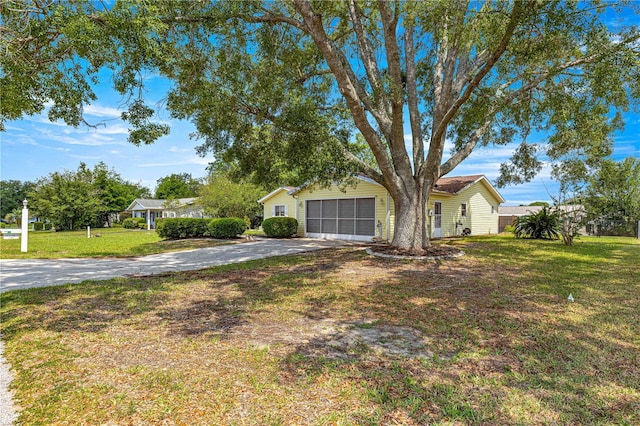 view of front facade featuring driveway, an attached garage, and a front yard