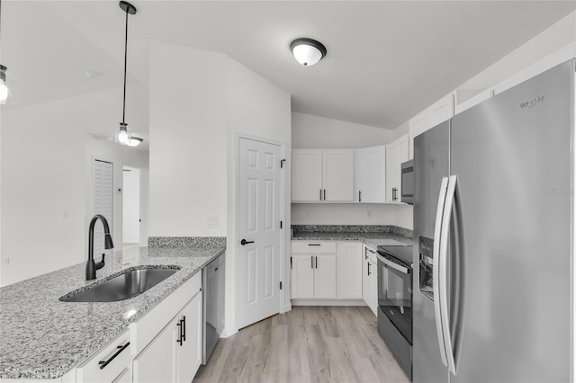 904 NW 67th St, Ocala, FL 34474 - kitchen with stainless steel appliances, lofted ceiling, a sink, a peninsula, and white cabinetry