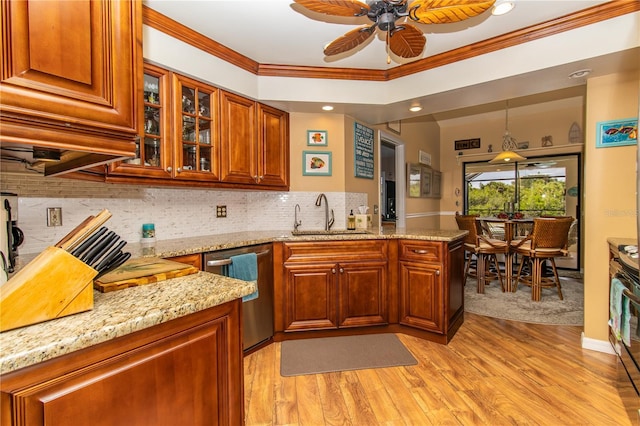 kitchen with a sink, stainless steel dishwasher, ceiling fan, a peninsula, and light stone countertops
