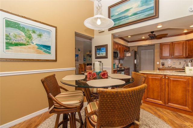 dining space featuring light wood-style flooring, baseboards, ceiling fan, ornamental molding, and recessed lighting