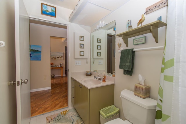 bathroom with vanity, toilet, baseboards, and wood finished floors