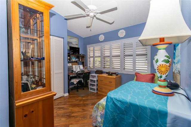 bedroom with wood finished floors, a desk, vaulted ceiling, a closet, and a ceiling fan
