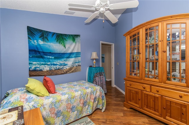 bedroom featuring wood finished floors, ceiling fan, and baseboards