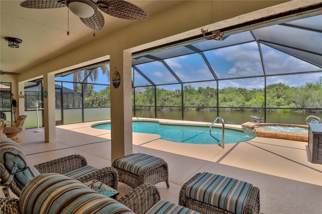 view of swimming pool with a water view, a patio, a ceiling fan, a pool with connected hot tub, and glass enclosure