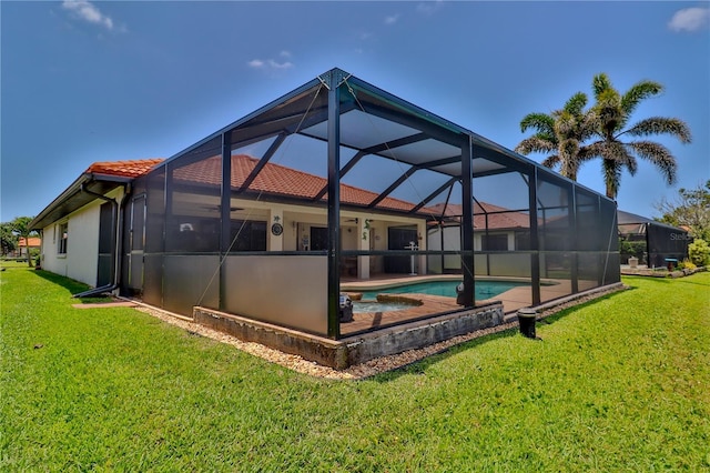 rear view of property featuring a tile roof, a lawn, an outdoor pool, and a lanai