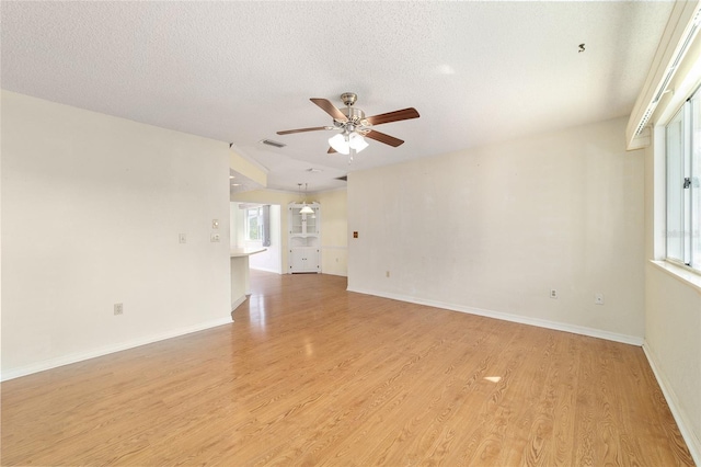 8375 SW 109th Lane Rd, Ocala, FL 34481 - unfurnished room with ceiling fan, light wood finished floors, healthy amount of natural light, a textured ceiling, and baseboards