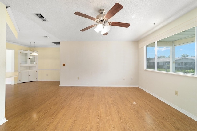 8375 SW 109th Lane Rd, Ocala, FL 34481 - spare room with a textured ceiling, ceiling fan, light wood-style floors, and baseboards