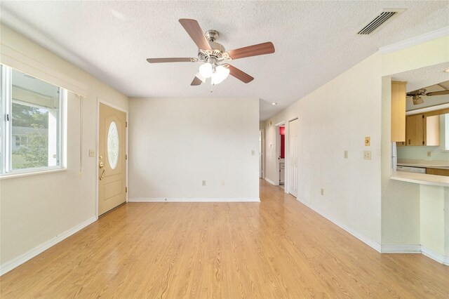 8375 SW 109th Lane Rd, Ocala, FL 34481 - unfurnished living room with a textured ceiling, a ceiling fan, light wood-style floors, and baseboards