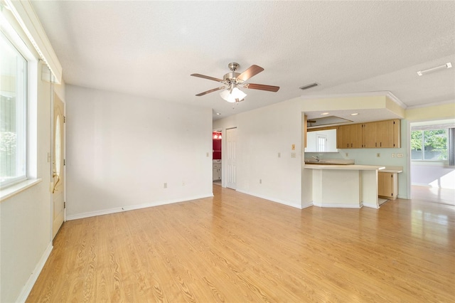 8375 SW 109th Lane Rd, Ocala, FL 34481 - unfurnished living room with light wood-type flooring, ceiling fan, a textured ceiling, and baseboards