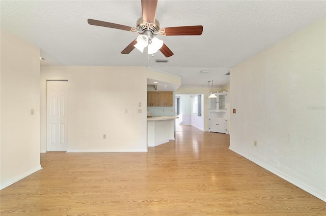 8375 SW 109th Lane Rd, Ocala, FL 34481 - unfurnished living room featuring ceiling fan, light wood-style floors, baseboards, and a textured ceiling
