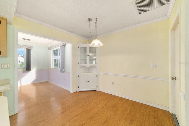 8375 SW 109th Lane Rd, Ocala, FL 34481 - unfurnished dining area featuring light wood-style flooring, crown molding, baseboards, and a textured ceiling