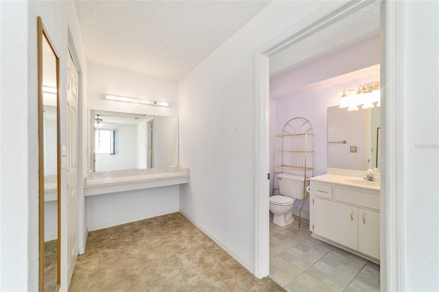 8375 SW 109th Lane Rd, Ocala, FL 34481 - bathroom with toilet, vanity, a textured ceiling, a ceiling fan, and baseboards