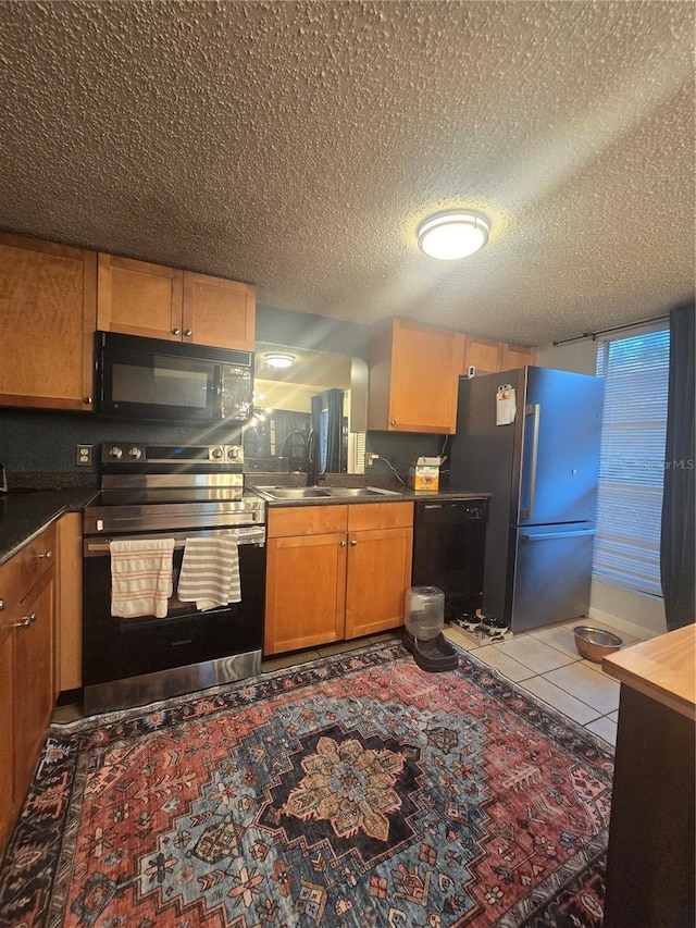 1810 NW 23rd Blvd Unit 230A, Gainesville, FL 32605 - kitchen with black appliances, a sink, a textured ceiling, dark countertops, and tile patterned flooring