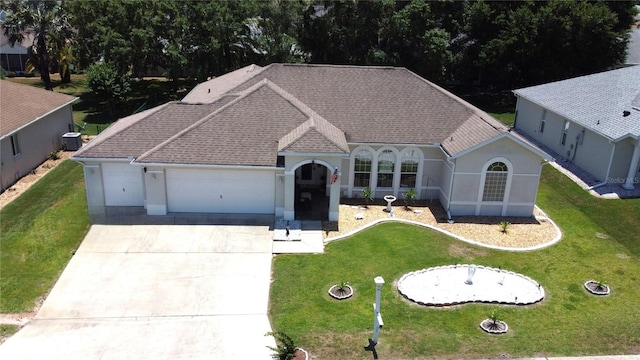 5340 NW 26th Ln, Ocala, FL 34482 - view of front facade with a garage, concrete driveway, cooling unit, a front lawn, and a shingled roof