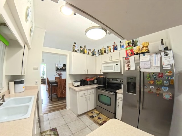 5340 NW 26th Ln, Ocala, FL 34482 - kitchen featuring stainless steel appliances, a sink, light countertops, light tile patterned floors, and white cabinets